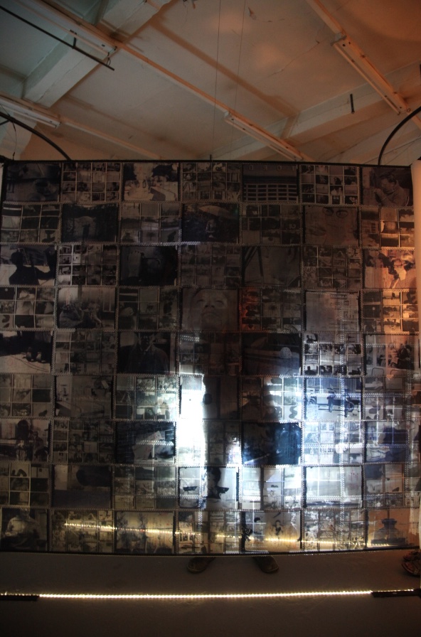 The wall of archival family photographs in Spoor by Natasha Bourke